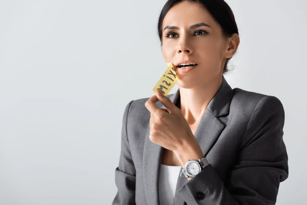 A woman removing tape from her lips.