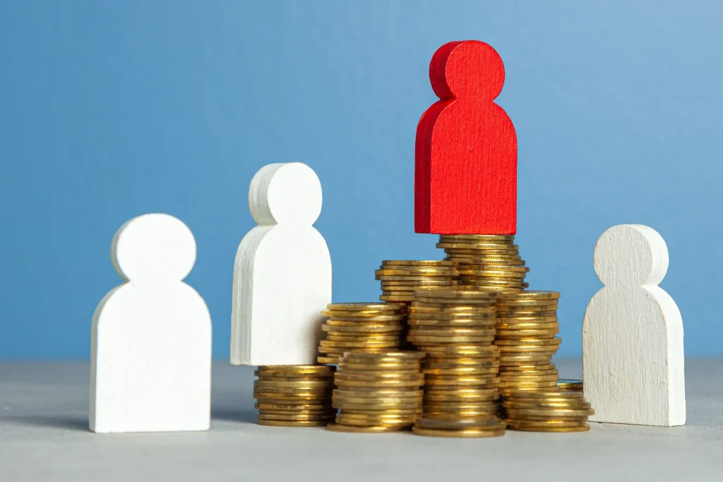 A figurine sitting on top of a pile of money with other sitting lower down. If you feel like you have been unfairly overlooked for a position at work you should consult with our employment discrimination lawyers in Kansas City.