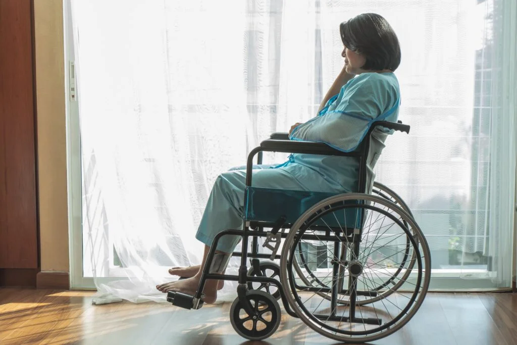 Injured woman sits on a wheelchair with an arm sling. Our team of knowledgeable Kansas City personal injury attorneys can help you get the compensation you deserve.