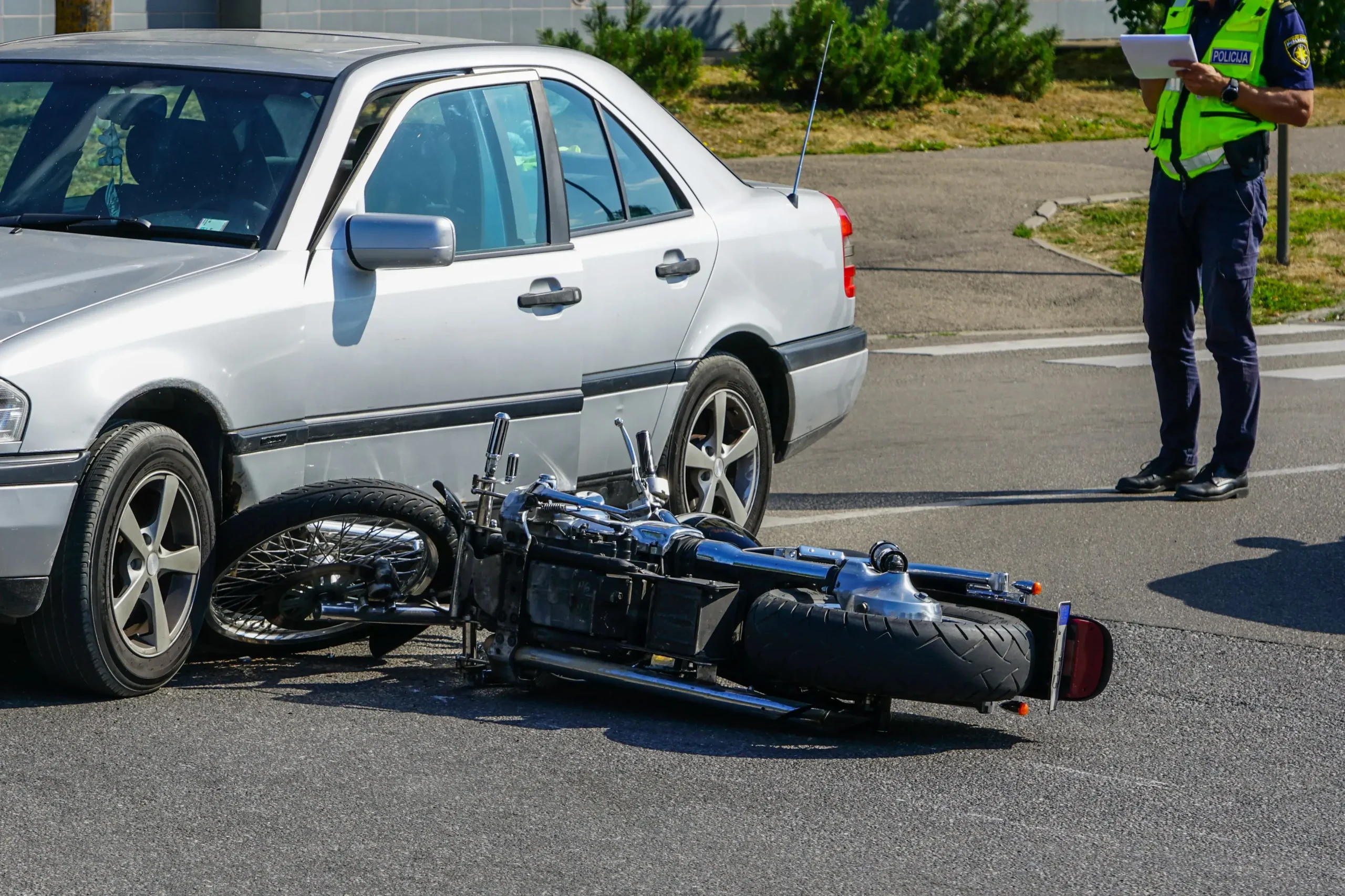 A bike lying next to a car that it crashed into.