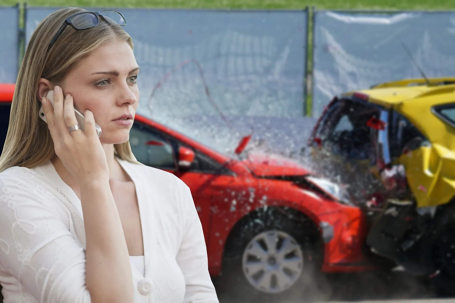 A woman on her cell phone after experiencing a car accident.